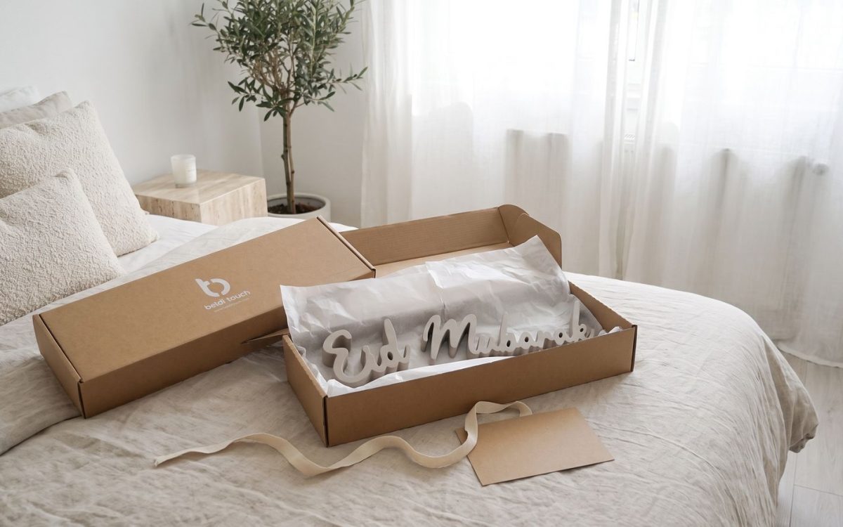 Geschenkbox Beldi Touch geöffnet mit den Worten Eid und Mubarak in grauer Holzmasse