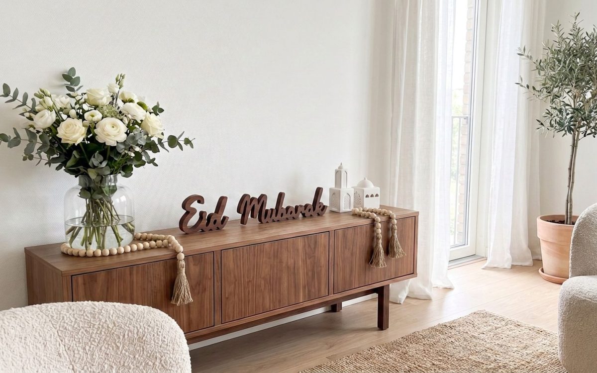 Eiddekoration auf einem Nussbaum-Buffet: Wörter „Eid“ und „Mubarak“ in Holz, Moscheekugeln und zwei Glitzerketten aus Holz