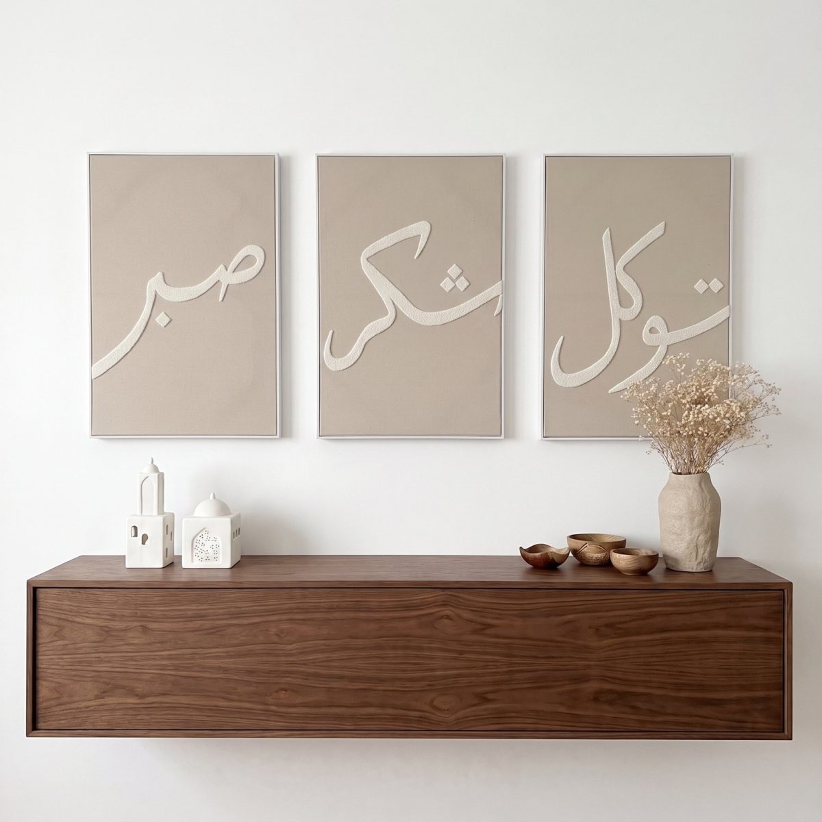 Triptyque tufté taupe Sabr, Shukr et Tawakkul en calligraphie beige au-dessus d’un meuble en bois
